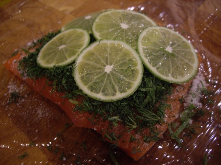 The salmon is first rubbed with the salt/sugar mix, then topped with dill and limes.